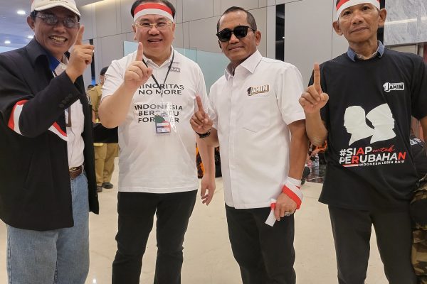 Mengenakan kaus putih bertuliskan " MINORITAS NO MORE INDONESIA BERSATU FOREVER" dan mengenakan ikat kepala Merah Putih, Bapak UMKM Jawa Barat ini tampak antusias melayani permintaan berfoto