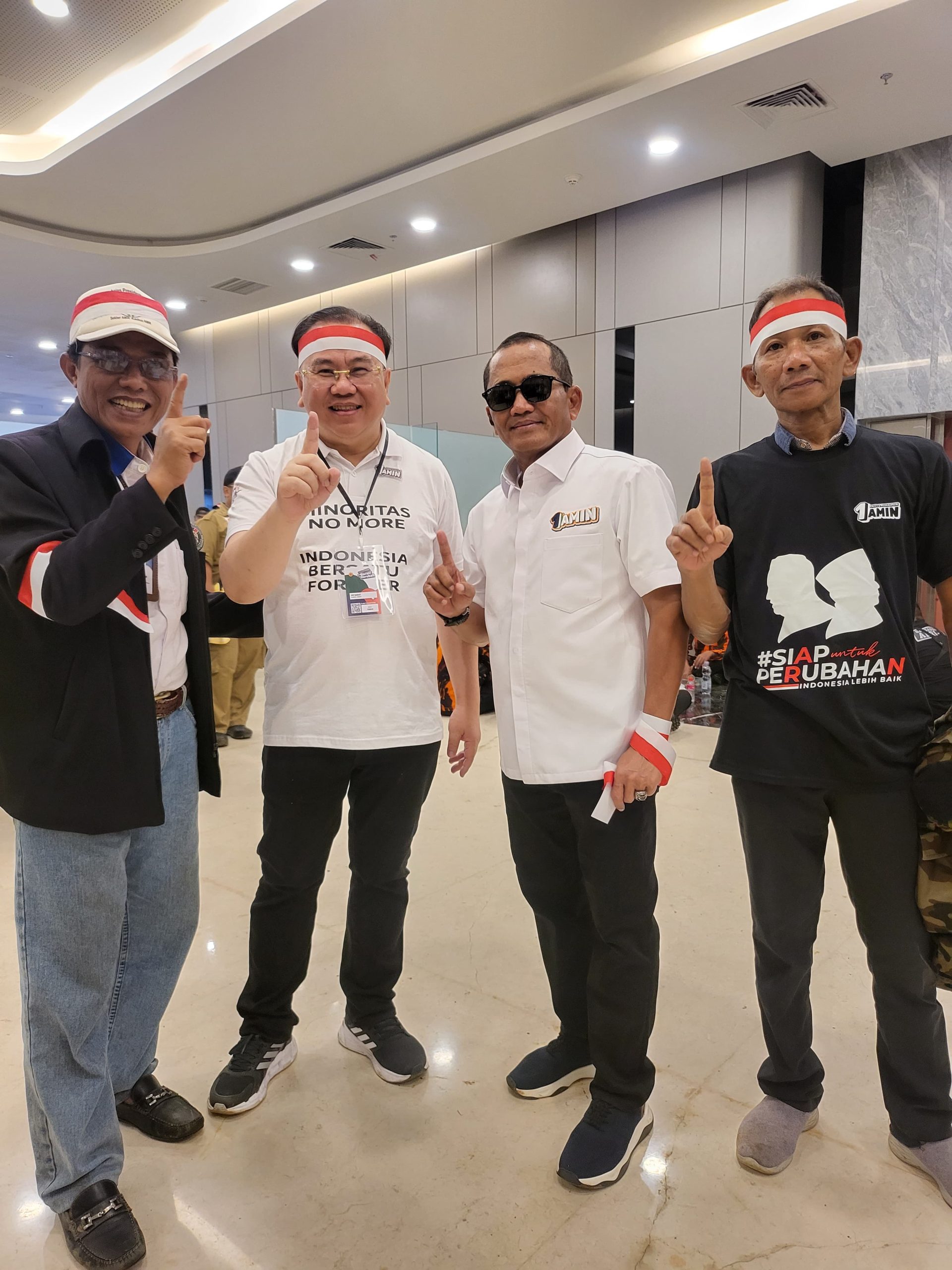 Mengenakan kaus putih bertuliskan " MINORITAS NO MORE INDONESIA BERSATU FOREVER" dan mengenakan ikat kepala Merah Putih, Bapak UMKM Jawa Barat ini tampak antusias melayani permintaan berfoto